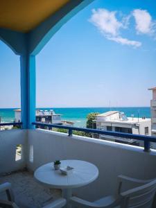 a balcony with a table and a view of the ocean at PIERIA MARE in Paralia Katerinis