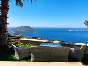 a patio with a table and chairs and the ocean at Villa Marlin in Kalkan