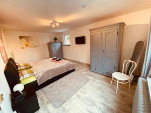 a bedroom with a bed and a cabinet and a chair at Ferienwohnung Könnecke Bad Harzburg in Bad Harzburg