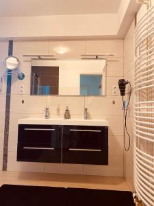 a bathroom with a sink and a mirror at Ferienwohnung Könnecke Bad Harzburg in Bad Harzburg +15 photos