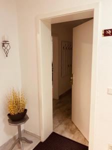 a hallway with a door and a table and a plant at Ferienwohnung Könnecke Bad Harzburg in Bad Harzburg