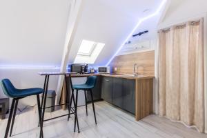 a kitchen with a table and two chairs and a sink at Studio Paris in Tourcoing