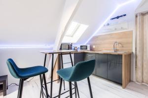 a kitchen with two chairs and a table and a sink at Studio Paris in Tourcoing +8 photos
