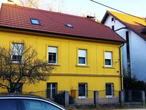 een geel huis met een rood dak bij 2LKT studio apartman in Zagreb