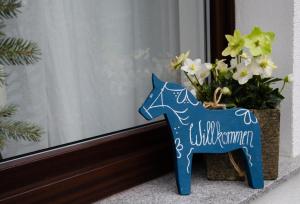 a blue figurine of a horse next to a vase of flowers at Pension Horn Bautzen in Bautzen