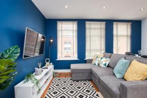 un soggiorno con pareti blu e divano di Stunning City Centre 3 Bed, 3 Bath - Sleeps 8! a Leeds