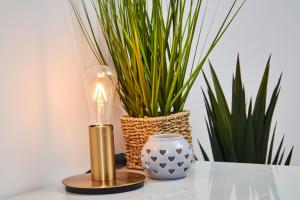 a lamp and a vase on a table with plants at Stunning City Centre 3 Bed, 3 Bath - Sleeps 8! in Leeds
