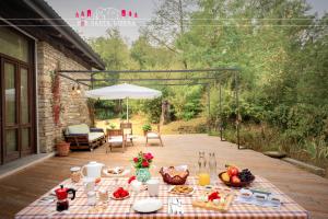 a picnic table on a wooden deck with a table cloth at B&B Santa Libera in Monastero Bormida