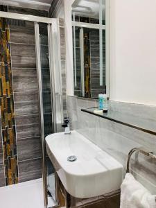 een badkamer met een witte wastafel en een douche bij The Compasses Inn in Fordingbridge
