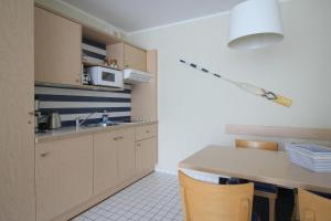 a kitchen with a sink and a table with chairs at Möwe App 510 in Zingst