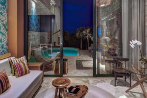 - un salon avec une piscine en arrière-plan dans l'établissement La Casa de la Playa by Xcaret- All Inclusive Adults Only, à Playa del Carmen