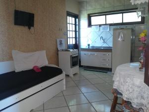 a room with a kitchen with a bed and a refrigerator at Pousada Ilha Margarita in Florianópolis