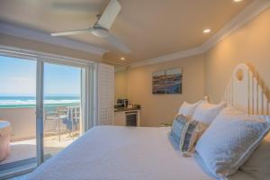 a bedroom with a bed and a view of the ocean at SeaVenture Beach Hotel in Pismo Beach