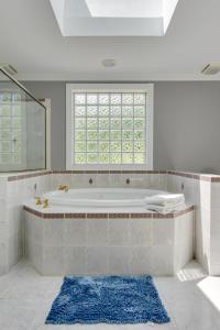 a white bathroom with a tub and a window at Country Cove in Brentwood