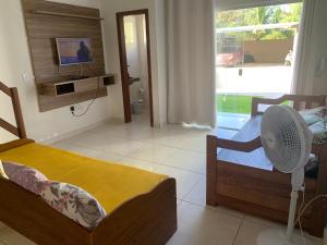 Habitación con 2 camas y ventilador. en Condominio Brasil Coroa, en Porto Seguro