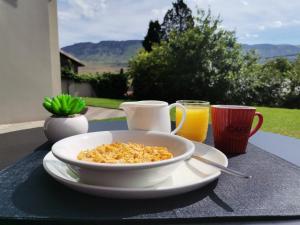 a bowl of cereal and two cups of orange juice at The Raz in Harrismith