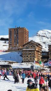 Un groupe de personnes dans la neige devant les bâtiments dans l'établissement Appartement 6 personnes - Deux chambres - 40M2 - Balcons 10M2 sur pistes - Aucun vis à vis - Piscine - B301, à Orcières