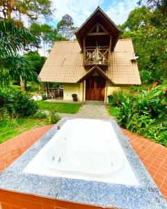 eine Badewanne vor einem Haus in der Unterkunft Chalé Suíço - Chalés Belo Monte - Sítio Belo Monte in Pacoti