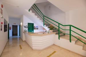 a staircase with green railings in a building with a sink at Hotel Apartamentos Villa Gomera in San Sebastián de la Gomera