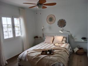 a bedroom with a bed with a ceiling fan at MI ALMA in Puerto del Carmen +25 photos