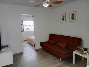 a living room with a brown couch and a bed at MI ALMA in Puerto del Carmen