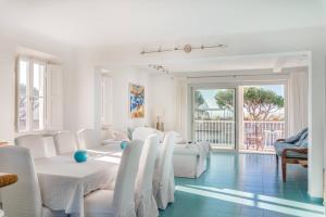 un soggiorno bianco con sedie bianche e un divano di Elegante Attico panoramico a 2 passi dal mare a Forte dei Marmi
