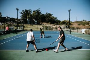 zwei Männer spielen Tennis auf einem Tennisplatz in der Unterkunft Posta Natural in Tandil