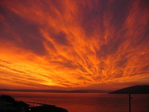 a fiery sunset over a body of water at Eola Leisure Rooms in Stara Baška