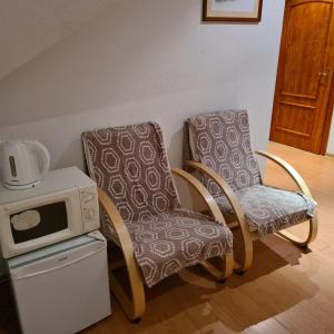 2 sillas y un microondas en una habitación en Restauracja Joanna, en Gogolin