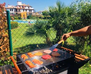 a person is cooking food on a grill at Costaesuri Vacaciones "Casa Vista" in Ayamonte