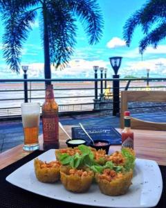 a plate of food on a table with a drink at Ecusuites Riverfront l Balcony in Guayaquil