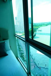 a bedroom with a window with a view of the water at Ecusuites Riverfront l Balcony in Guayaquil +54 photos
