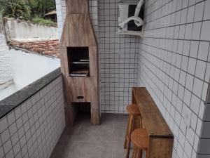 uma cozinha com um banco e um forno de pizza em Apartamento Cereja do Mar em Ubatuba