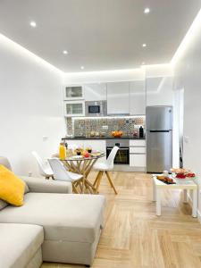 Una sala de estar con un sofá blanco y una cocina. en Apartamentos SweetHomes, en Faro