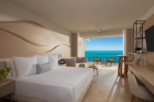 a bedroom with a bed and a view of the ocean at Breathless Cancun Soul Resort & Spa - Adults Only - All Inclusive in Cancún
