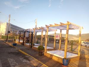 a row of wooden beds in a parking lot at Pousada Brisamar Morro dos Conventos in Conventos