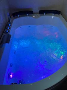 a bath tub filled with blue water with lights at B&B LA REGGIA DI RIHANNA spa in Caserta