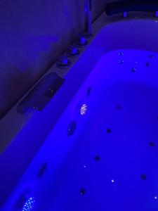 Cette chambre sombre dispose d'une baignoire avec des lumières bleues. dans l'établissement B&B LA REGGIA DI RIHANNA spa, à Caserte
