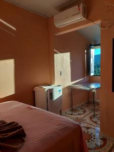 een kamer met een bed, een tafel en een raam bij Pousada da Lurdinha in Lençóis