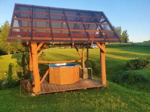 einen Pavillon mit einem Sonnendach auf einem Feld in der Unterkunft Sodyba PEIZAŽAS in Kirdeikiai