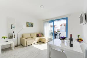 a white living room with a couch and a table at Apartments Villa Pina in Vodice