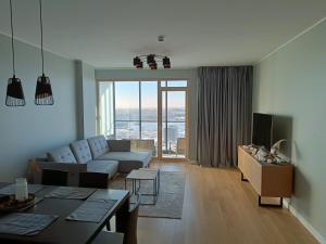a living room with a couch and a table at SEA GATE APARTMENT 20th floor in Klaipėda