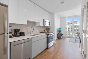a kitchen with white appliances and a large window at Global Luxury Suites Downtown White Plains in White Plains