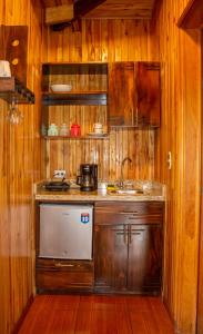 eine Küche mit Holzwänden, einem Waschbecken und einer Theke in der Unterkunft Hotel Holístico Monteverde in Monteverde Costa Rica