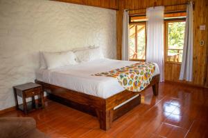 ein Schlafzimmer mit einem Bett in einem Zimmer mit einem Fenster in der Unterkunft Hotel Holístico Monteverde in Monteverde Costa Rica