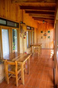 Hotel Holístico Monteverde في مونتيفيردي كوستاريكا: غرفة طعام مع طاولتين خشبية ونوافذ