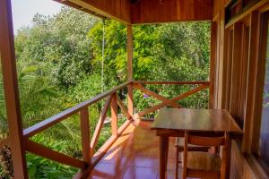Hotel Holístico Monteverde في مونتيفيردي كوستاريكا: غرفة مع طاولة وكراسي على شرفة