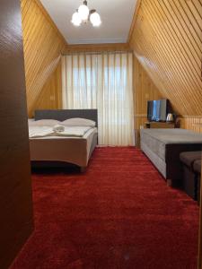 a bedroom with two beds and a red carpet at Pokoje Gościnne Madzia in Poronin