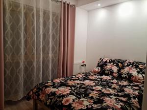 a bedroom with a bed with a floral blanket at Fala Bałtyku Apartament Nadmotławie in Gdańsk