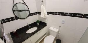 a bathroom with a sink and a mirror and a toilet at Local Ideal - Lindo apartamento em Teresópolis in Teresópolis +2 photos